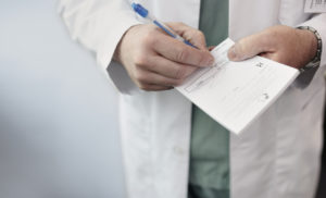 Doctor writing an illegal prescription for pills. IN West Palm Beach this is known as a pill mill.