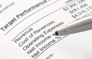 A pen is pointing to the financial statements of a person that has been charged with RICO in West Palm Beach.